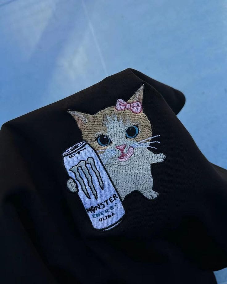 Katze mit Monster-Energy-Dose, gestickt auf schwarzem Stoff
